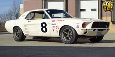 an old race car is parked in front of a building with the number eight on it