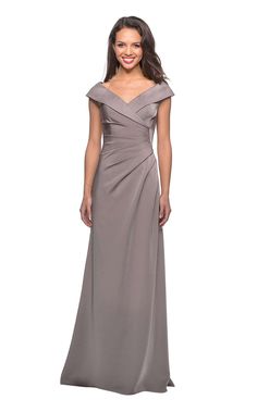 Tip-of-the-shoulder sheath gown with V-neck and ruched details by La FemmeFeel like you are entering the venue on the red carpet with the figure-flattering gown from La Femme 26523. Its broad V-cut fold over neckline frames the bodice with tip-of-the-shoulder design and ruched details that flow on to the skirt. The gown flares slightly from the waist and ends at floor length. Mother Of The Bride Dresses Long, Mother Of Groom Dresses, Mob Dresses, Floor Length Gown, Stunning Gowns, Satin Gown, Bride Style, Groom Dress, Livingston