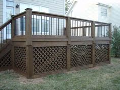 a wooden deck in front of a house with lattice design on the top and bottom