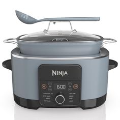 the ninja slow cooker is on display with a spoon in its top and lid