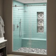 a bathroom with a walk in shower next to a white sink and tiled flooring