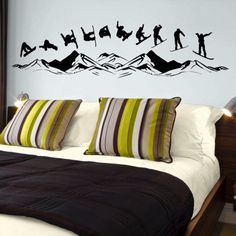 a bed sitting in a bedroom next to a wall with ski decals on it