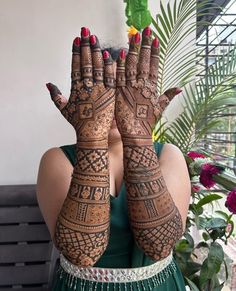 a woman holding her hands up with hendi tattoos on it's arms and chest