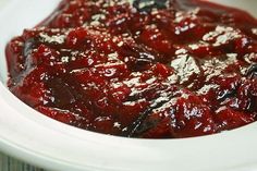 a white bowl filled with cranberry sauce on top of a table