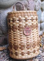 a woven basket sitting on top of a rug next to a stone wall with a heart in it