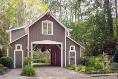 a brown and white barn surrounded by trees