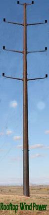 a tall pole sitting in the middle of a field with power lines attached to it