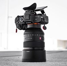 a camera sitting on the ground with its lens attached to it's back end