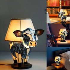 a cow lamp sitting on top of a table next to a bed