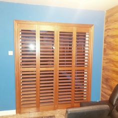 a living room with blue walls and wooden slats on the doors, leather recliner