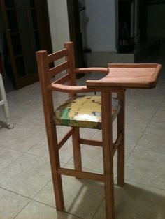 a wooden chair with a tray on top of it sitting in front of a counter