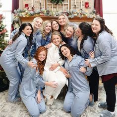 a group of women standing next to each other in front of a christmas tree