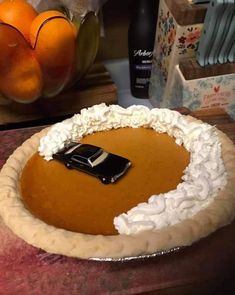 there is a pie with whipped cream and a car in the middle on top of it