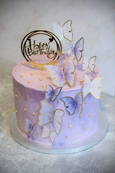 there is a purple cake with butterflies on it