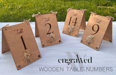 wooden table numbers are displayed on a white cloth covered table with grass in the background