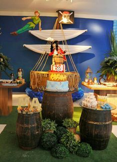 a pirate ship cake is on display in front of other cakes and desserts at a children's birthday party