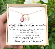 a person holding up a pink heart necklace in a box with the message you are so experienced