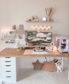 a desk with a computer on top of it next to a teddy bear and other items