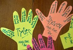 three handprints with writing on them sitting on top of a wooden table next to each other