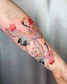 a woman's arm with a bird and flowers on it