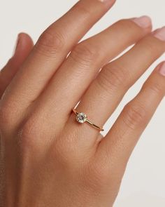 a woman's hand with a diamond ring on top of her finger and the other hand holding it