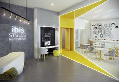 the interior of an office with yellow accents and white walls, along with tables and chairs