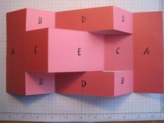 the letters are cut out of pink paper