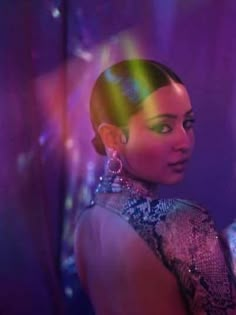 a woman standing in front of a mirror with her hair styled into a high bun