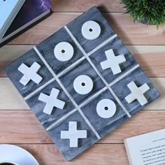 a tic - tac - toe game on a table next to a cup of coffee