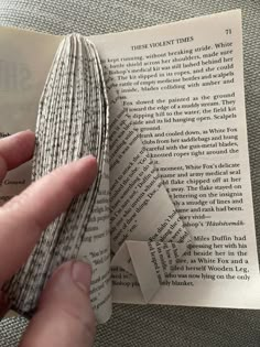 someone is holding an open book with folded pages