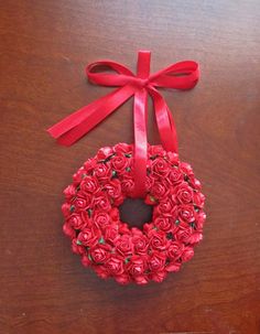 a red rose wreath with a bow on a table