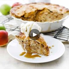 a piece of pie sitting on top of a white plate next to an apple pie