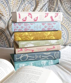 a stack of books sitting on top of a bed