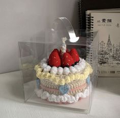 a cake with strawberries is in a clear box