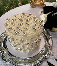 a white cake sitting on top of a silver plate