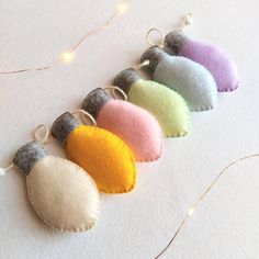 five different colored felt ornaments hanging from strings