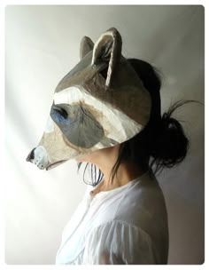 a woman wearing a paper mask with a bear head on it's face in front of a white background