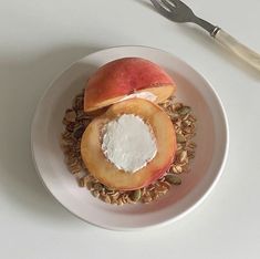 an apple and oatmeal dish on a white plate with a fork next to it