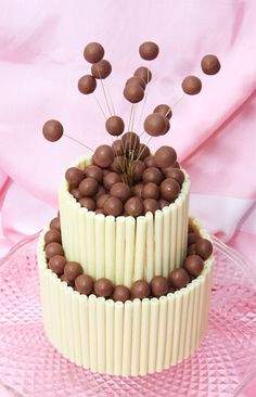 a three tiered cake with chocolate candies on top