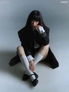 a woman sitting on the ground with her legs crossed and wearing stockings, knee high socks