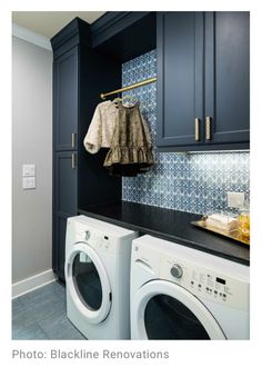 a washer and dryer sitting next to each other in a room with blue cabinets