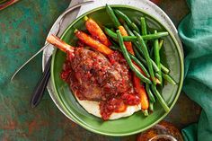 a green plate topped with meat and veggies