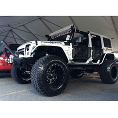 a white jeep is parked under a tent