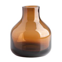 a brown glass vase sitting on top of a white table next to a black base