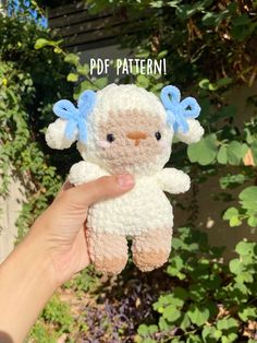 a hand holding a small stuffed animal in front of some trees and bushes with the words, pdf pattern on it