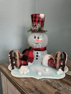 a snowman sitting on top of a wooden table