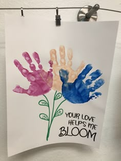 handprints are displayed on a white paper with the words, your love helps me bloom