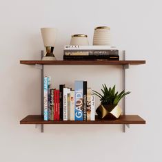 two wooden shelves with books, plants and vases sitting on top of each shelf