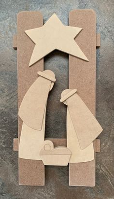 paper cut out of the shape of a manger scene with a star above it