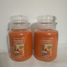 two glass jars filled with orange colored candles